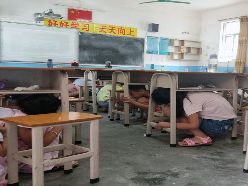 图二：学生钻在桌子底下进行紧急避险.jpg